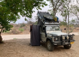 Honey Badger the Defender standing at the campsite 1 in Chitake Springs, Mana Pools National Park, Zimbabwe. It had great views to the dry riverbed!